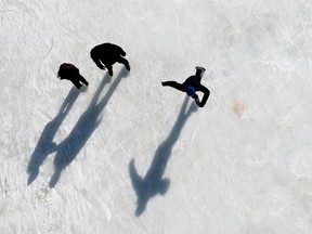 A top down photo shows three skaters on the Rideau Canal Skateway, and their long shadows