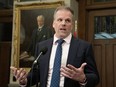 Minister of Health Mark Holland gestures to a reporter as he takes questions in the Foyer of the House of Commons on Wednesday, Feb. 28, 2024, in Ottawa.