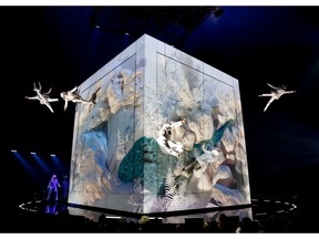 Cirque du Soleil acrobats appear to fly off a giant cube in the centre of a stage
