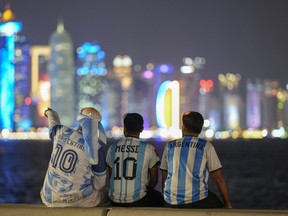 Fans of Argentina sit on Doha corniche, in Doha, Qatar, Monday, Dec. 12, 2022. Toronto and Vancouver are set to get a tourism boost from the World Cup, but one expert warns to be wary of rosy projections.