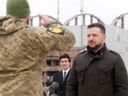 Prime Minister Justin Trudeau watches as Ukrainian President Volodymyr Zelenskyy is saluted by soldiers during a ceremony at Hostomel Airport in Kyiv on Feb. 24, 2024. The ceremony was part of a day of commemorations to mark the second anniversary of the start of the war in Ukraine.