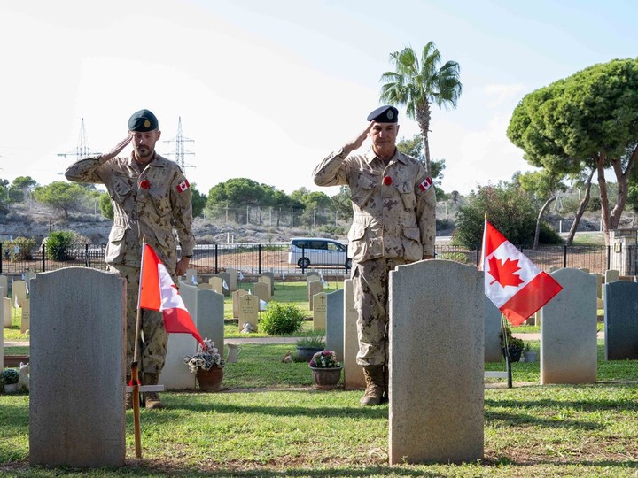  Canadian Armed Forces members deployed to Cyprus as part of Operation LUMEN place flags on the graves of fallen Canadian soldiers at the Dhekelia Garrison British Military Cemetery in Larnaca, Cyprus, Nov. 10, 2023.