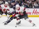 Senators defenceman Jacob Bernard-Docker (right) skates for the puck against Columbus Blue Jackets’ Dmitri Voronkov.