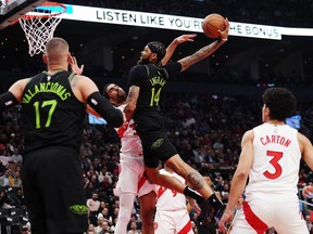 New Orleans Pelicans forward Brandon Ingram (14) dunks over Toronto Raptors centre Jontay Porter (34) as Pelicans centre Jonas Valanciunas (17) and Raptors guard D.J. Carton (3) look on during first half NBA basketball action in Toronto on Tuesday, March 5, 2024.