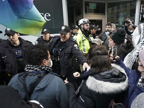 Police clash with protesters outside a fundraising event for Prime Minister Justin Trudeau, in Toronto, Friday, March 15, 2024. Rebel News personality David Menzies was among two people charged.