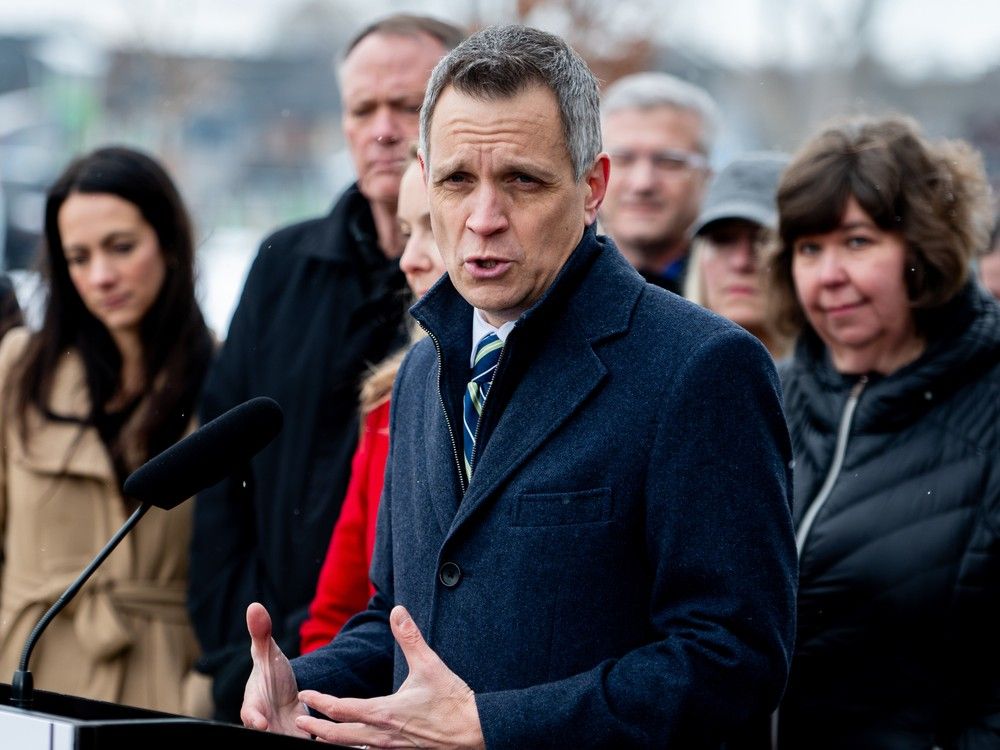 Mayor Mark Sutcliffe, flanked by MPs and other local politicians,  announces the city's share from the federal housing funding Feb. 12.
