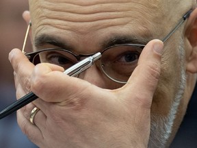 Parliamentary budget officer Yves Giroux adjusts his glasses as he waits to appear before the Senate Committee on National Finance, Tuesday, October 17, 2023 in Ottawa. Giroux is projecting the federal deficit will grow amid weakening economic conditions.