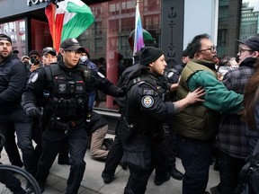 Police clash with protesters outside a fundraising event for Prime Minister Justin Trudeau, in Toronto, Friday, March 15, 2024.
