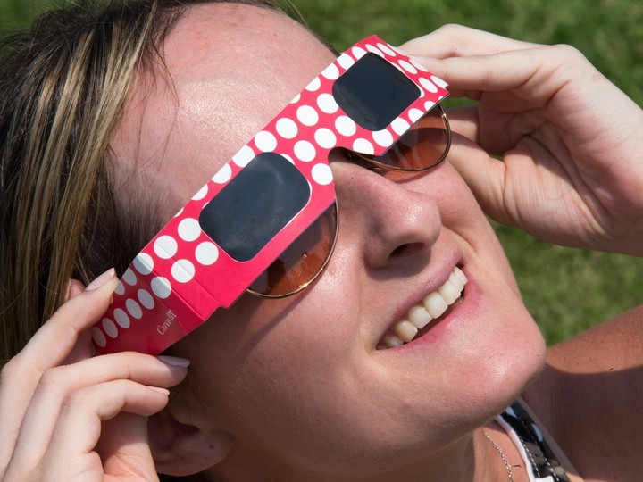  Jessica Keating uses special viewing glasses as the partial solar eclipse is observed at an event held by the Royal Astronomical Society at the Canadian Aviation and Space Museum in Ottawa.