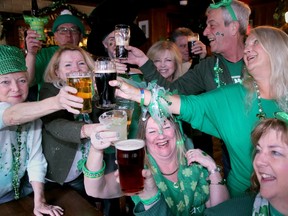 A group of women toast St. Patrick's Day in a bar