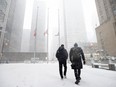 Pedestrians make their way through Toronto's downtown core as a winter storm starts to hit the city Wednesday, Jan. 25, 2023.