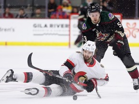 Mark Kastelic (12) of the Ottawa Senators attempts to control the puck ahead of Michael Carcone of the Arizona Coyotes during the second period of a game at Mullett Arena in Tempe on Dec. 19, 2023.