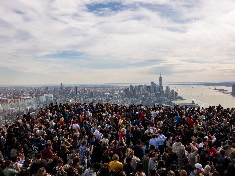  NEW YORK, NEW YORK – APRIL 08: People watch a partial solar eclipse on the observation deck of Edge at Hudson Yards on April 08, 2024 in New York City. While New York City isn’t in the path of totality, it will see up to 90% of the sun covered by the moon. Around New York and in the path of totality, millions of residents and tourists are preparing for a total solar eclipse.