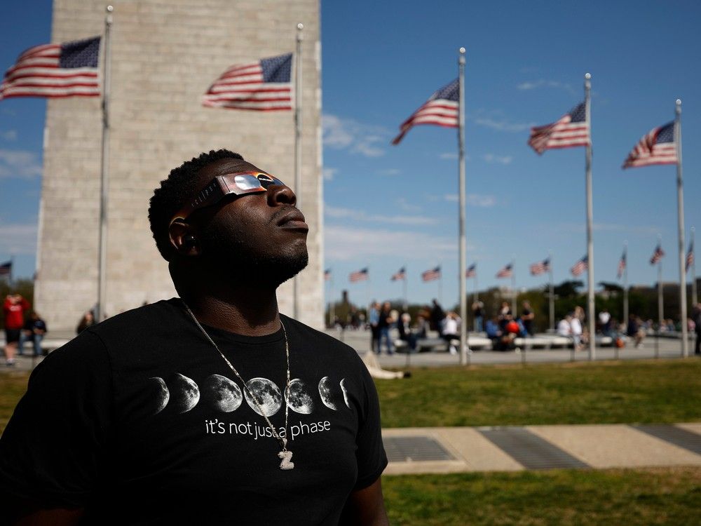 WASHINGTON, DC – APRIL 08: Zion Edwards of Grand Prairie, Texas, looks at the solar eclipse through two pair of mylar filter glasses near the base of the Washington Monument on the National Mall on April 08, 2024 in Washington, DC. People have traveled to areas across North America that are in the “path of totality” in order to experience the eclipse today, with the next total solar eclipse that can be seen from a large part of North America won’t happen until 2044.