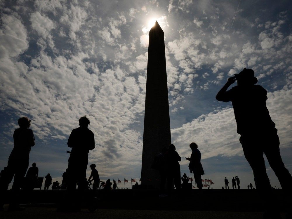  WASHINGTON, DC – APRIL 08: Photographers capture the solar eclipse near the base of the Washington Monument on the National Mall on April 08, 2024 in Washington, DC. People have traveled to areas across North America that are in the “path of totality” in order to experience the eclipse today. The next total solar eclipse that can be seen from a large part of North America won’t happen until 2044.