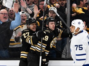 John Beecher #19 of the Boston Bruins celebrates with Hamphus Lindholm #27 after scoring a goal as Ryan Reaves #75 of the Toronto Maple Leafs looks on in Game One.