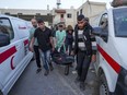 Palestinians carry the body of a World Central Kitchen worker at Al Aqsa hospital in Deir al-Balah, Gaza Strip, Tuesday, April 2, 2024. A Canadian-American citizen is among the seven aid workers who were killed by an apparent Israeli airstrike in Gaza.