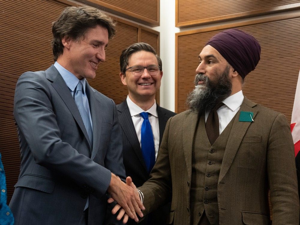 Prime Minister Justin Trudeau shakes hands with New Democratic Party leader Jagmeet Singh as Conservative leader Pierre Poilievre looks on, Monday, Jan. 30, 2023 in Ottawa.