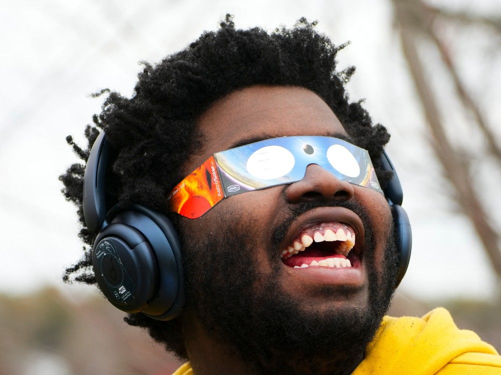  Didier Timothy-Mondesir watches the solar eclipse from Prince Edward County, Ont., Monday, April 8, 2024.