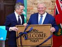 上周，渥太华市长马克·萨克利夫（左）在市政厅向安大略省省长道格·福特赠送了欢迎垫。