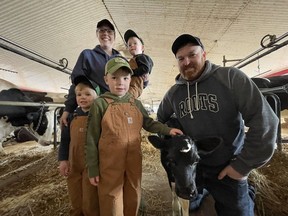 Jill and Matt Carey and their three sons, Patterson, 2, Macauley, 3, and Sullivan, 5, gather with their calf, Eclipse, at their Inverary dairy farm on Saturday, April 13, 2024. The heifer was born on the day of the total solar eclipse that darkened the sun over the Kingston region on April 8, 2024. The calf sports a crescent-shaped marking on her forehead, commemorating the once-in-a-lifetime celestial event.