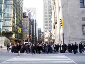 Pedestrians cross Front Street in the financial district of Toronto.