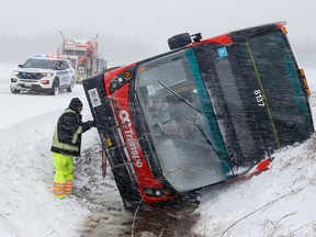 A double decker bus sits on its side in the ditch on Frank Kenny Road in Ottawa Thursday. A Ottawa snow storm caused havoc on the roads early Thursday morning.
