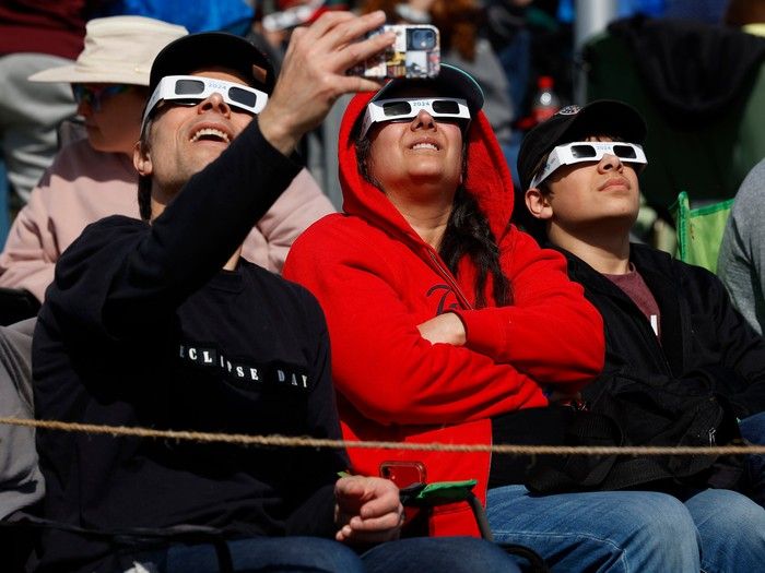 Families and friends take in the eclipse at Crysler's Farm outside Cornwall Monday.