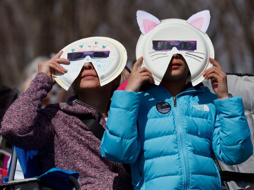  Families and friends take in the eclipse at Crysler’s Farm outside Cornwall Monday.