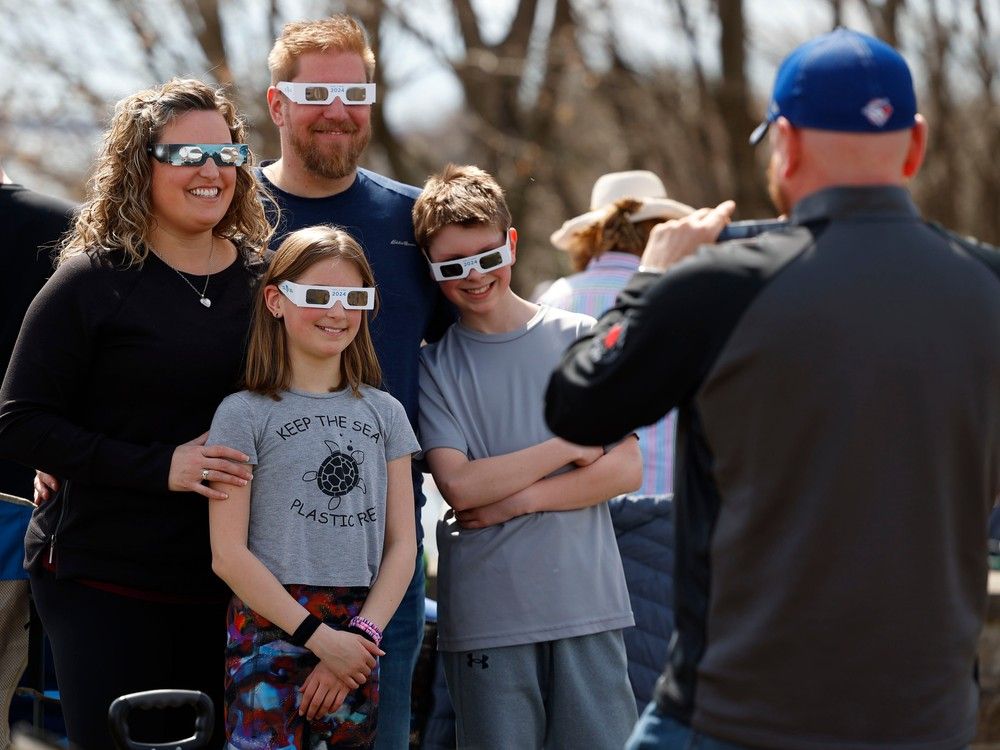  Families and friends take in the eclipse at Crysler’s Farm outside Cornwall Monday.