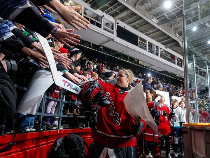 PWHL Ottawa goalie Emerance Maschmeyer (38) receives a gift from a fan following warmup and ahead of a regular season matchup against PWHL New York in Ottawa on Wednesday, Feb. 28, 2024.