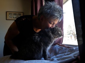 Janice Richard poses for a photo with Athena, a pregnant rescue cat from Manitoba, which has been found 11 days after disappearing at the Ottawa airport.