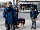 OTTAWA: Community Engagement Team (CET) member Rachel Douglas, centre, alongside service dog Kobe and fellow CET member Terrence Lei, speak to a member of the community (name withheld) in the Centretown neighbourhood in Ottawa on Tuesday Feb. 27, 2024.