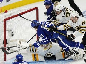 Boston Bruins goaltender Jeremy Swayman makes a save on Toronto Maple Leafs' Tyler Bertuzzi (59) as Bruins' Hampus Lindholm (27) and Brandon Carlo (25) defend and Maple Leafs' Auston Matthews (34) looks on during third period action in Game 3 in Toronto on Wednesday, April 24, 2024.