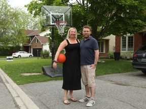 Couple with basketball net on driveway