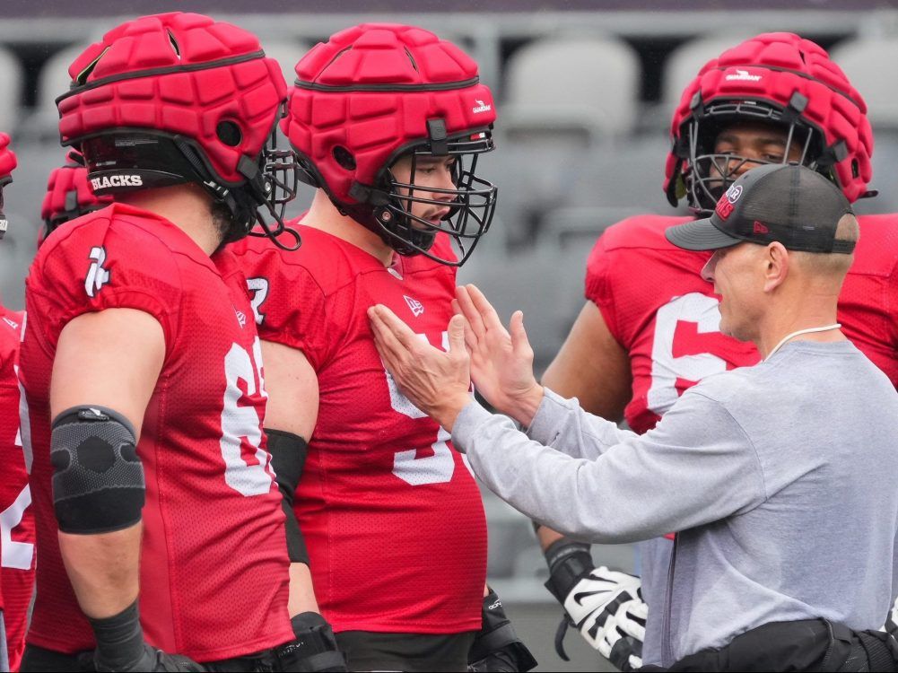 Ottawa Redblacks centre Cyrille Hogan-Saindon (centre) and other offensive linemen listen to offensive line coach Pat Perles during a team workout earlier this month. 