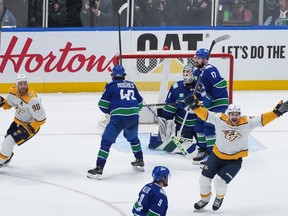 Nashville Predators' Filip Forsberg, front right, and Ryan O'Reilly (90) celebrate a goal by Alexandre Carrier, not seen, against Vancouver Canucks goalie Arturs Silovs, back right, as Filip Hronek (17) and Quinn Hughes (43) look on during the third period in Game 5 of an NHL hockey Stanley Cup first-round playoff series, in Vancouver, on Tuesday, April 30, 2024.