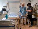 Alex Packham, a rehab assistant, helps Peter at the Queensway Carleton Hospital in Ottawa.