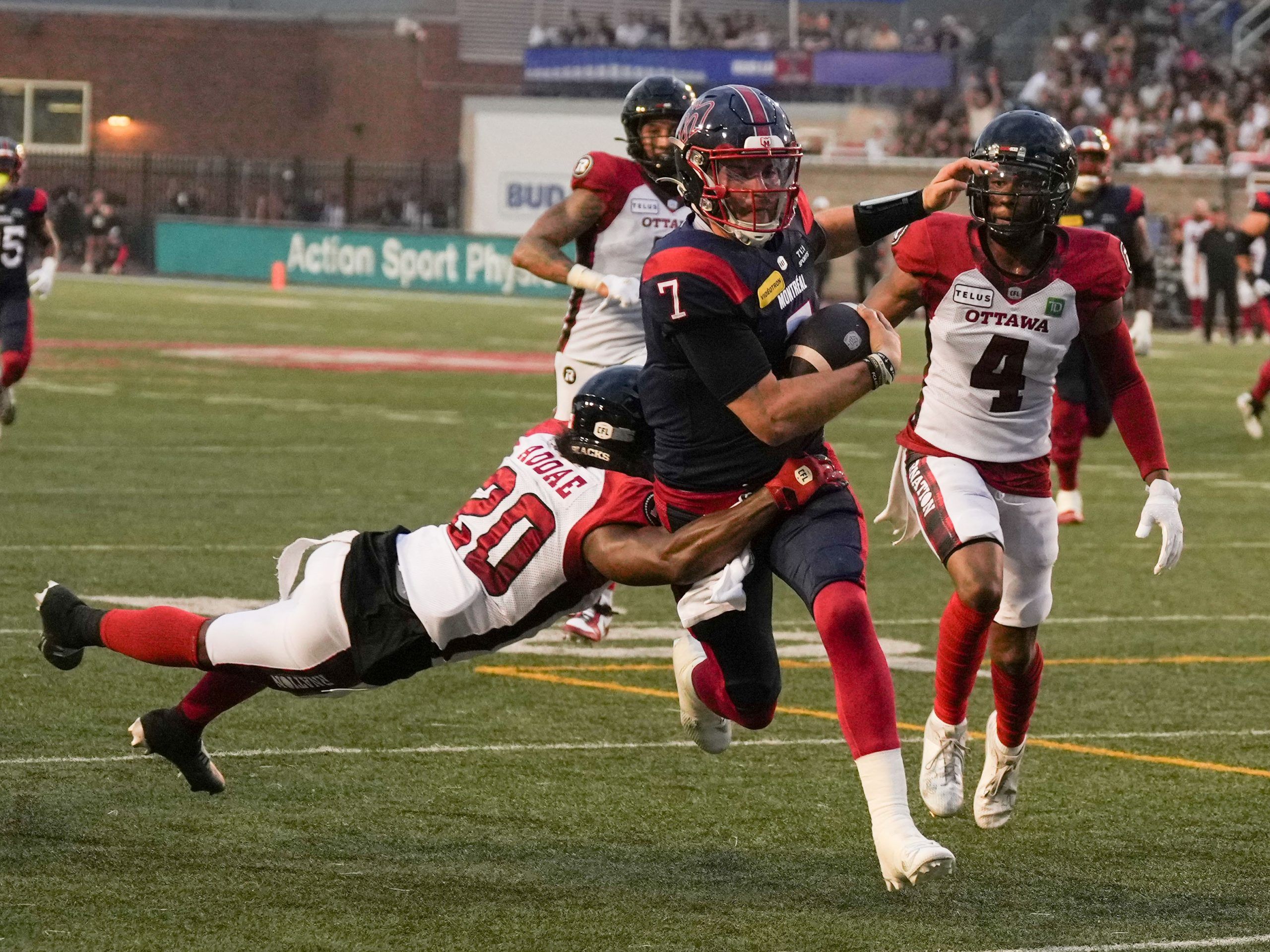 Montreal Alouettes quarterback Cody Fajardo is tackled by Ottawa Redblacks defensive back Alonzo Addae as he runs for yardage. 