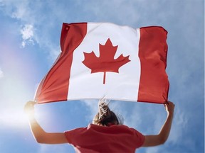 Person holding up big Canadian flag