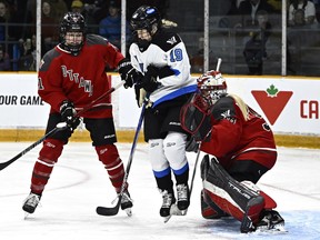 Toronto's Rebecca Leslie jumps to keep out of the way of a shot as she screens Ottawa goaltender Emerance Maschmeyer last season.