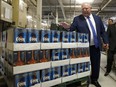 Premier Doug Ford slaps the top of boxes of beer