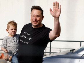 Elon Musk holds his son X Æ A-12 during a visit at Tesla's electric car plant near Berlin on March 13, 2024.