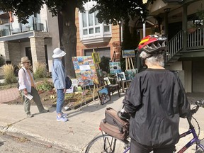 People look at paintings outside an Ottawa home.