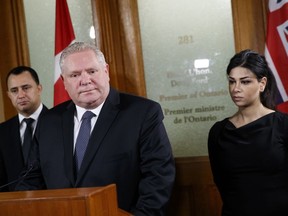 Ontario Premier Doug Ford is flanked by MPPs Michael Parsa, left, and Goldie Ghamari, as he announces a scholarship fund to honour the victims of the Iran plane crash, during a news conference in Toronto, Thursday, Jan. 16, 2020.