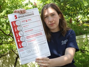 Megan Francoeur of Ottawa Public Health displays information about what to do in an overdose situation.