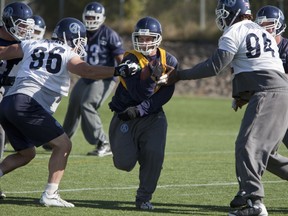 Former Toronto Argos running back Bryan Crawford pushes past defenders at practice in 2010.