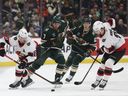 2024年12月29日、ミネソタ州セントポールでのNHL試合の第1ピリオドで、オタワ・セネターズのディフェンスマン、トーマス・シャボットとセンターのジョシュ・ノリスがパックを操り、ミネソタ・ワイルドのディフェンスマン、ブロック・フェイバーがプレッシャーをかけている。