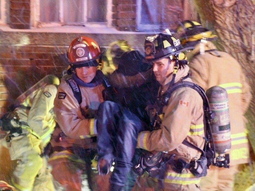 Firefighters assist a resident who suffered smoke inhalation at a fire Wednesday on Bronson Avenue. The person was not seriously injured, firefighters said.