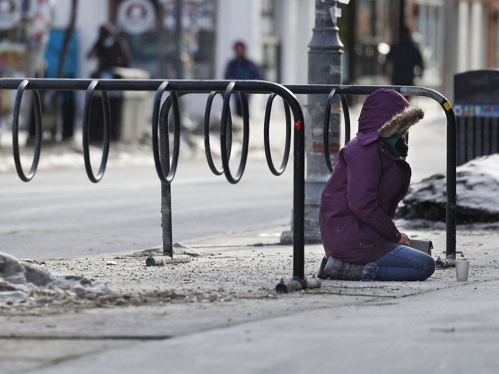 A photo taken on Jan. 9 shows a homeless person sits in front of a store on Bank Street in downtown Ottawa.